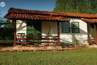 Chalé com varanda, rede e jardim na Pousada Recanto do Guará